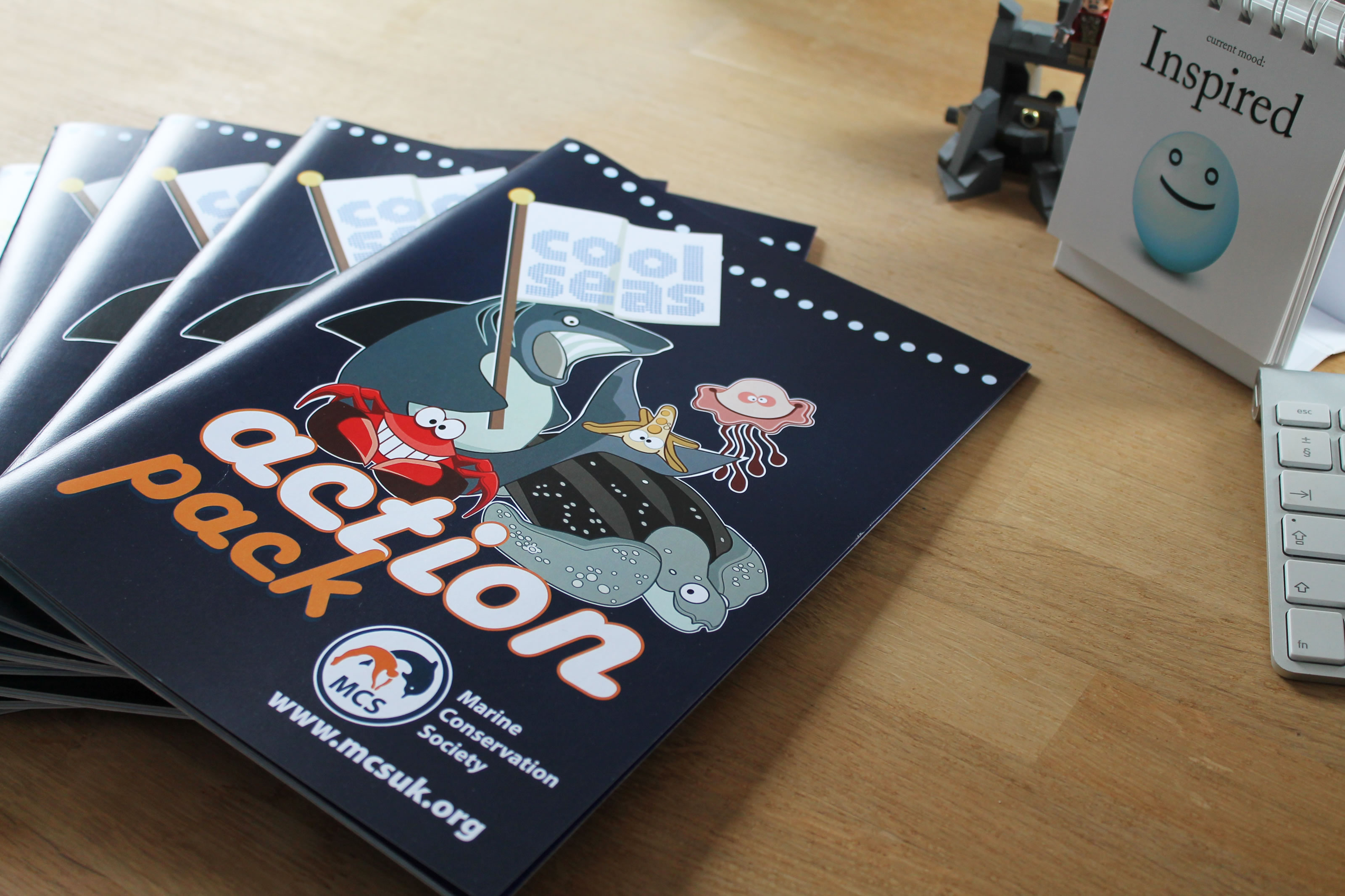 Image of printed workbook on desk featuring team characters on the cover